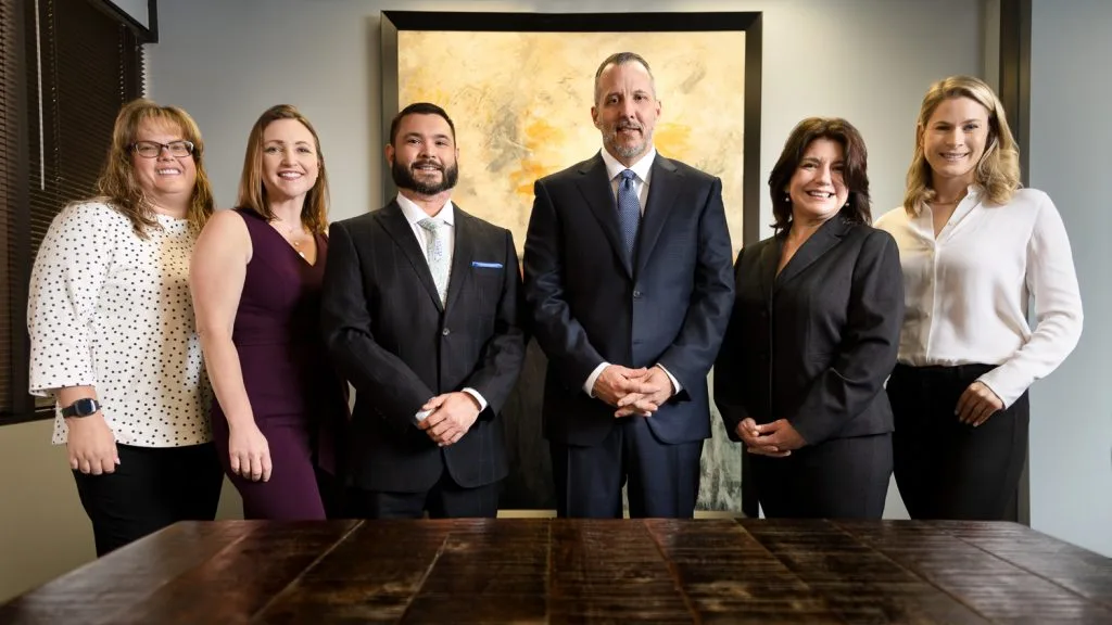 Eric M. Willie, P.C. attorney and staff standing together in a conference room